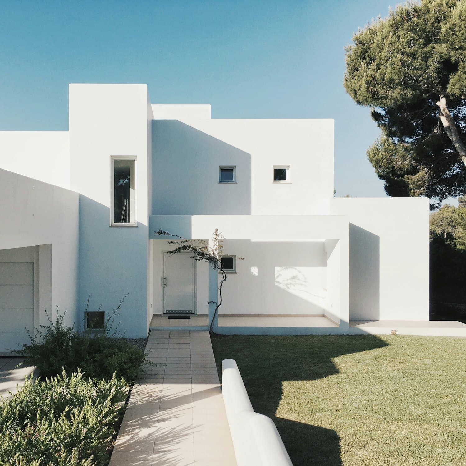 Fachada de una vivienda moderna de líneas rectas, iluminada de costado